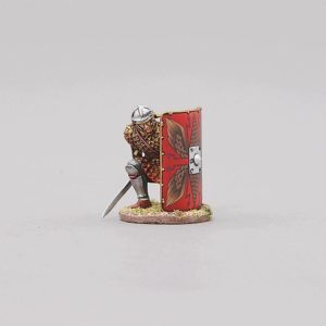 the last member of the group in beautiful scale armour peers from behind his shield waiting for the command to go