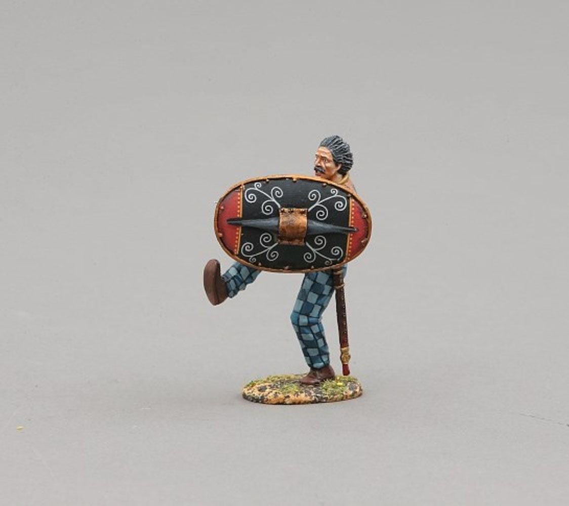 Ancient Briton adorned with tattoos with red and black shield